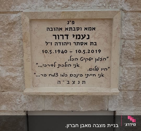 מצבה עם כיתוב בעברית על קיר אבן
